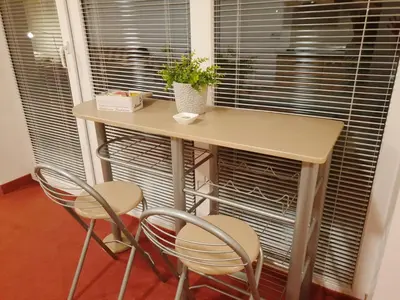 a table and two chairs in front of a window at Red Rose Apartment in Moravske Toplice