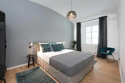 a bedroom with a bed and a large window at Apartments Rog in Ljubljana