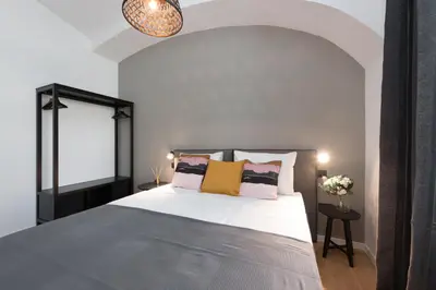 a bedroom with a large bed with pillows at Apartments Rog in Ljubljana