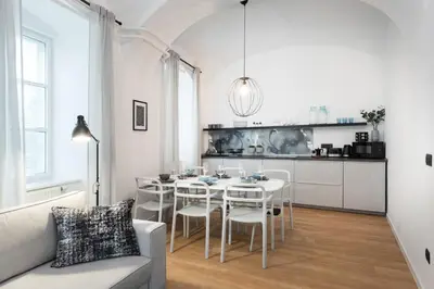 a white dining room with a table and chairs at Apartments Rog in Ljubljana
