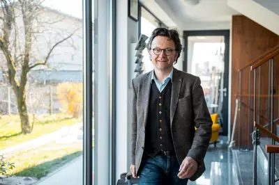 a man standing in front of a window at Apartments Villa Popp in Ljubljana