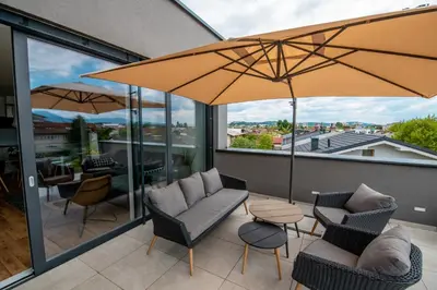 a patio with two chairs and an umbrella at Apartments Villa Popp in Ljubljana