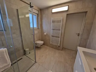 a bathroom with a glass shower and a toilet at Patricia House in Ljubljana