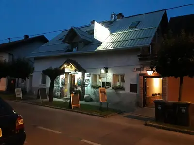 a large white house with signs in front of it at Hostel Piero in Ljubljana