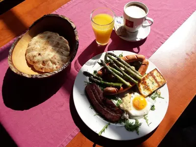 a table with a plate of breakfast food and a cup of coffee at Hostel Piero in Ljubljana