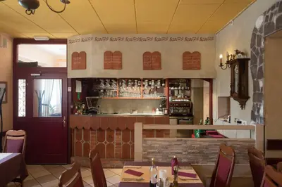 a restaurant with a bar with tables and chairs at Hostel Piero in Ljubljana