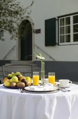 a table with a plate of fruit and glasses of orange juice at Vila Monet in Laško