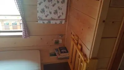 a tiny house with a bed and a window at Gnezdo Vid-ik in Čatež ob Savi