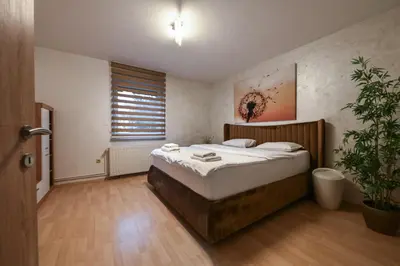 a bedroom with a bed and a potted plant at Apartments in Villa Olimp in Ljubljana