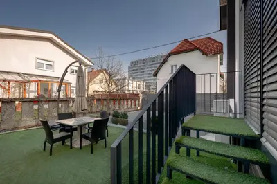 a patio with a table and chairs on a balcony at Apartments in Villa Olimp in Ljubljana