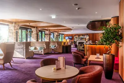 a hotel lobby with tables and chairs at HABAKUK Wellness & Event Hotel in Maribor