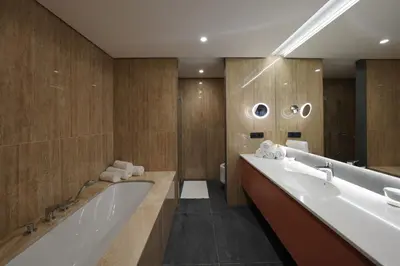 a bathroom with a large tub and a large mirror at HABAKUK Wellness & Event Hotel in Maribor