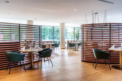 a restaurant with wooden walls and tables and chairs at HABAKUK Wellness & Event Hotel in Maribor