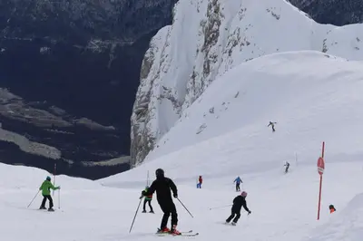 a group of people skiing down a snow covered mountain at Pristava Lepena Village in Lepena