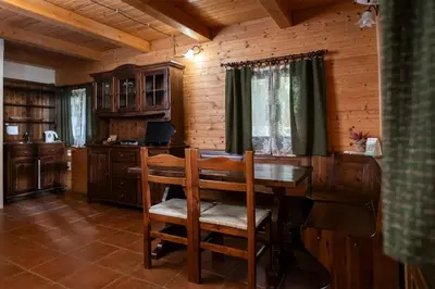 a dining room with a table and chairs in a cabin at Pristava Lepena Village in Lepena