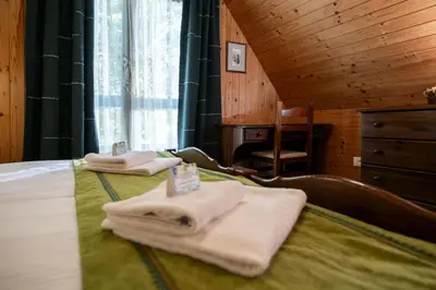 two towels are sitting on a bed in a room at Pristava Lepena Village in Lepena