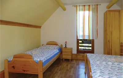 a bedroom with two beds and a window at 2 Bedroom Stunning Home In Luce in Luče