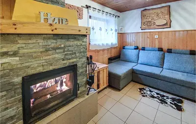 a living room with a fireplace and blue couches at 2 Bedroom Stunning Home In Luce in Luče