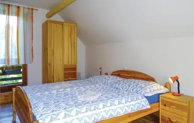 a bedroom with a bed and a wooden cabinet at 2 Bedroom Stunning Home In Luce in Luče