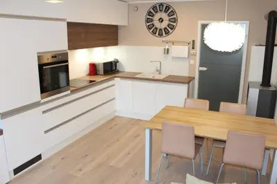 a kitchen with white cabinets and a wooden table at ApBovec in Bovec