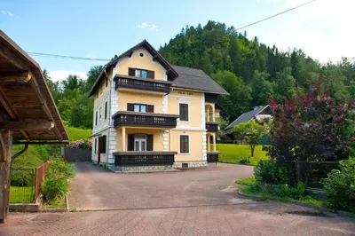 a large yellow house with a black roof at Vila Lipa in Bled
