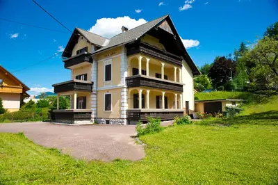 a large house on a hill with a green yard at Vila Lipa in Bled