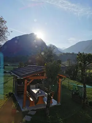 a picnic table with a picnic bench in a field at Apartma Miko in Bovec