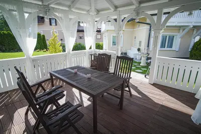 a wooden table and chairs on a porch at Vacation House Vila Mia in Bled