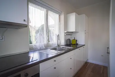 a kitchen with white cabinets and a sink and a window at Vacation House Vila Mia in Bled