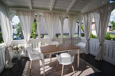 a table and chairs in a room with windows at Vacation House Vila Mia in Bled
