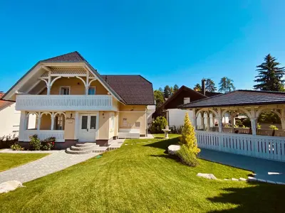 a house with a white fence and a yard at Vacation House Vila Mia in Bled