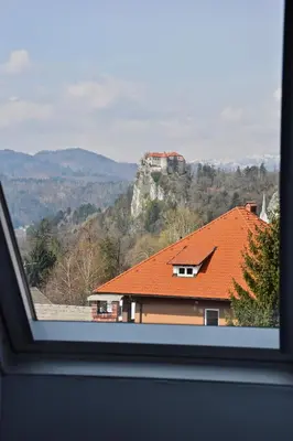 a view of a house with a mountain in the background at Vacation House Vila Mia in Bled