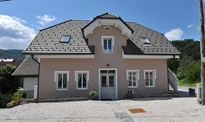a pink house with a black roof at Vila Sol in Bled