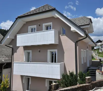 a pink house with white balconies on it at Vila Sol in Bled