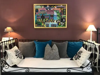 a couch with pillows and a picture on the wall at Vila Sol in Bled