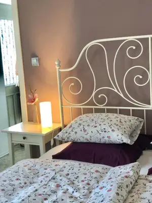 a bedroom with a bed with a metal headboard and a table at Vila Sol in Bled