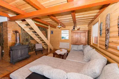 a living room with a couch and a stove at Koča na Planini in Planina pod Sumnikom
