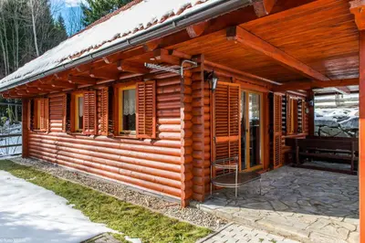 a cabin with wooden shutters on the side of it at Koča na Planini in Planina pod Sumnikom