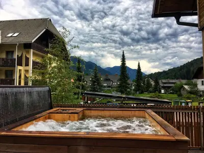 a hot tub on the balcony of a house at House Neza in Kranjska Gora