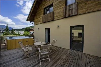 a patio with a table and chairs on a deck at House Neza in Kranjska Gora