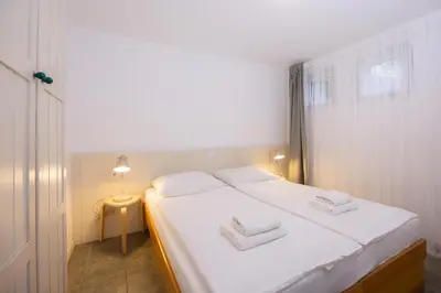 a bedroom with a white bed with two white towels at Apartments Baki Kranjska Gora in Kranjska Gora