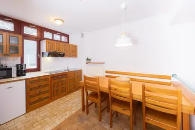 a kitchen with wooden cabinets and a wooden table and chairs at Apartments Baki Kranjska Gora in Kranjska Gora