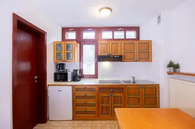 a kitchen with wooden cabinets and a white refrigerator at Apartments Baki Kranjska Gora in Kranjska Gora