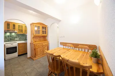 a kitchen with a wooden table and wooden cabinets at Apartments Baki Kranjska Gora in Kranjska Gora