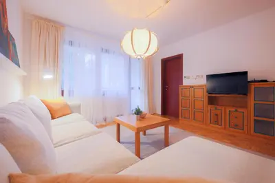 a living room with a white couch and a television at Apartments Baki Kranjska Gora in Kranjska Gora