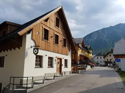 a building with a wooden roof on a street at Hotel Vandot in Kranjska Gora