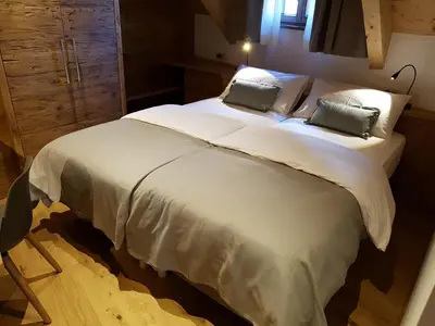 a bedroom with a large white bed with two pillows at Hotel Vandot in Kranjska Gora