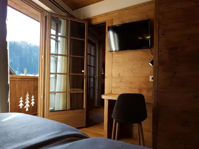 a bedroom with a bed and a desk and a television at Hotel Vandot in Kranjska Gora