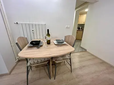 a dining room table with a bottle of wine and chairs at Apartment TiSa, Bled in Bled