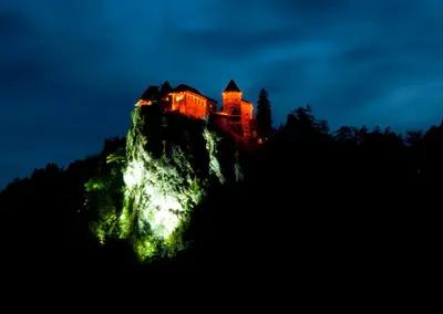 a castle on top of a mountain at night at Apartment TiSa, Bled in Bled